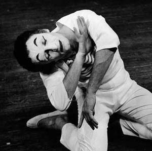 Famous mime Marcel Marceau, on his knees, lays his head to one side while holding both arms vertical in front of him. Like mimes do.