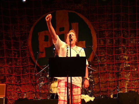 Rock music legend John Lydon raises a fist as he performs with Public Image Ltd.